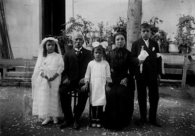 Niños de primera comunión acompañados por sus padres, retrato de familia