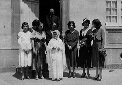 Niña de primera comunion acompañada de familiares, retrato de familia