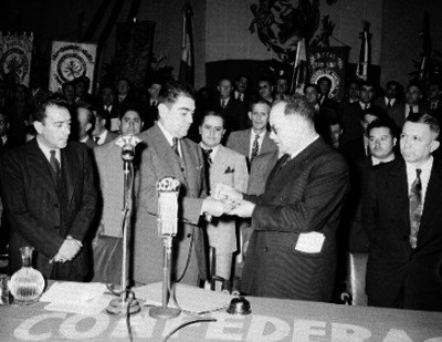 Líderes sindicales entregando un reconocimiento a un hombre en el 8° aniversario de la C.N.C. en el palacio de Bellas Artes