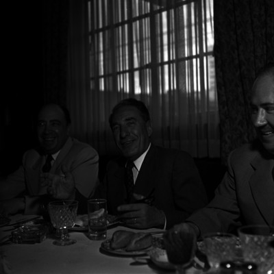 Martín Luis Guzmán comiendo con otros hombres