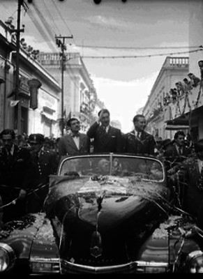 Miguel Alemán y Jesús González saludando a la gente desde un carro descubierto