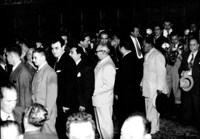 Miguel Alemán conversando con funcionarios públicos en un salón de Palacio Nacional
