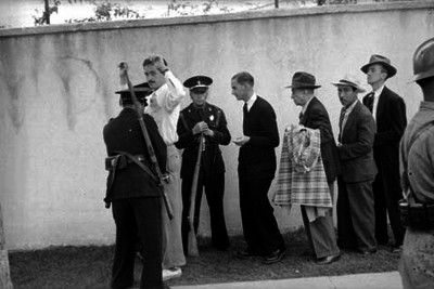 Policias revisando a civiles durante las votaciones