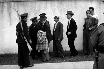 Policias revisando a civiles durante las votaciones