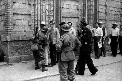 Soldados revisando a hombres durante las votaciones