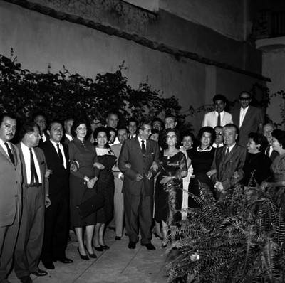 Adolfo López Mateos en compañía de funcionarios y mujeres en el patio de un edificio