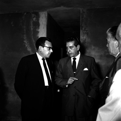 Adolfo López Mateos conversando con funcionarios en una habitación