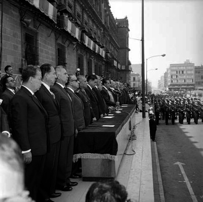 Adolfo López Mateos y otras dos personas presidiendo ceremonia militar de jura de bandera