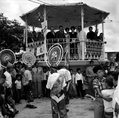 Adolfo López Mateos, Antonio M. Quirosco y comitiva observando desde un kiosko la interpretación de una danza folclórica
