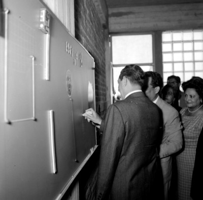 Adolfo López Mateos escribiendo en el pizarrón de una salón