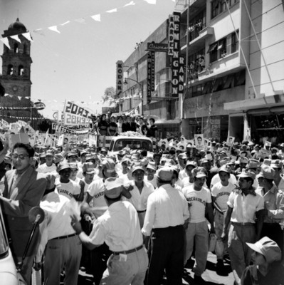 Adolfo López Mateos acompañado por mujeres en un camión, recorriendo las calles de Guadalajara, durante su campaña política