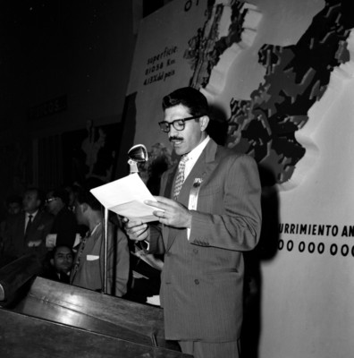 Político leyendo un discurso en una asamblea económico-social durante la campaña de adolfo López Mateos en Guadalajara