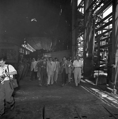 Adolfo López Mateos visitando una planta industrial, acompañado de otras personas, durante su campaña política por Monclova
