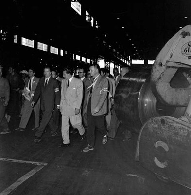 Adolfo López Mateos con otras personas recorriendo las instalaciones de una planta industrial, durante su campaña política por Monclova