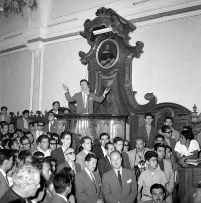 Hombre pronunciando un discurso en la Universidad de Puebla
