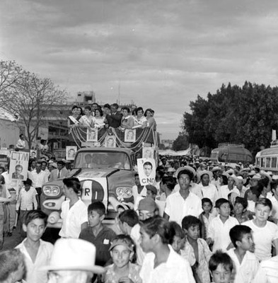 Adolfo López Mateos y edecanes en un camión, haciendo un recorrido durante su campaña electoral