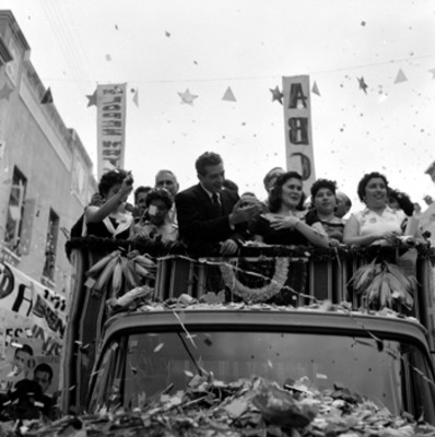 Adolfo López Mateos con mujeres a bordo de un camión saludando a partidarios