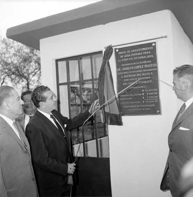 Adolfo López Mateos develando la placa inaugural del Abastecimiento de agua potable del ejido del Retablo acomapañado de Juan C. Gorraez y Alfredo del Mazo en Qro