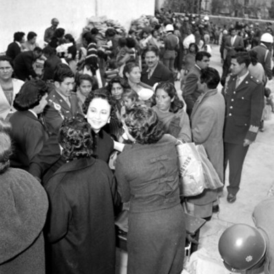 Eva Sámano de López Mateos y otras mujeres repartiendo ropa a pobres