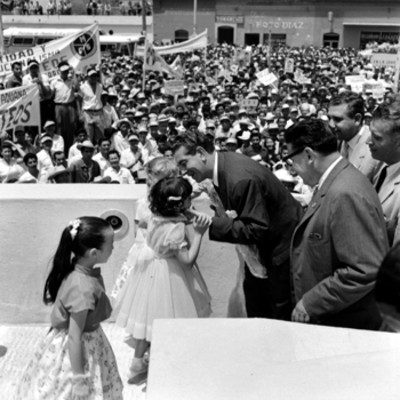 Adolfo López Mateos recibiendo flores de una niña durante un mitin de apoyo a su campaña en Guaymas