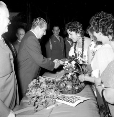 Adolfo López Mateos recibiendo de mujeres flores y frutas en una ceremonia, durante su gira de trabajo por Durango