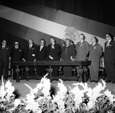 Adolfo López Mateos pronunciando un discurso en compañía de David Franco Rodríguez y otras personalidades en una ceremonia
