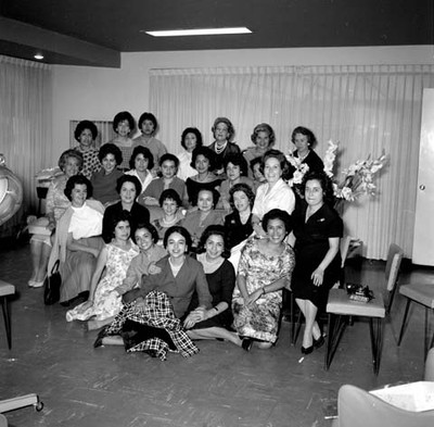 Eva Sámano con peinadoras en un salón de peinados durante su inauguración, retrato de grupo