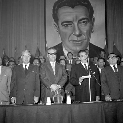Adolfo López Mateos pronunciando un discurso en el congreso de la CTM en compañía de Fidel Velázquez Sánchez y otros líderes