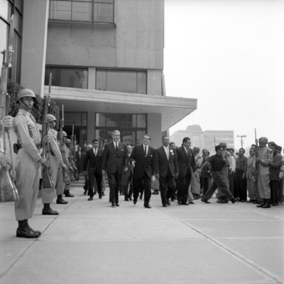 Adolfo López Mateos, Salomón Gónzalez Blanco y demás personalidades caminando frente a un guardia de soldados
