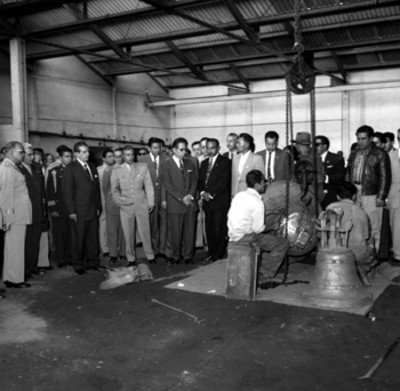 Adolfo López Mateos, Ernesto P. Uruchurtu y conitiva observando a un hombre trabajar en un taller