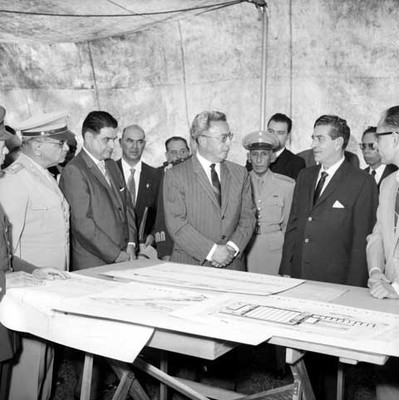 Adolfo López Mateos con Ernesto P. Uruchurtu y funcionarios públicos observan planos de una fábrica de armas