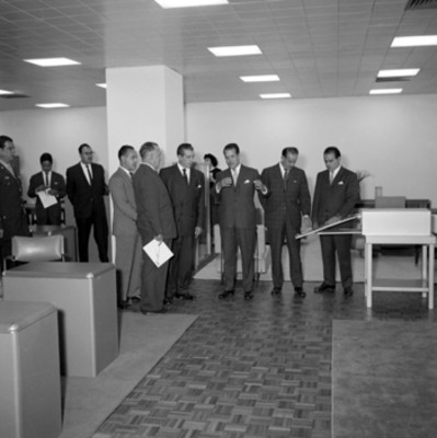 Adolfo López Mateos y funcionarios acompañados por empresarios recorriendo la instalaciones de D.M. Nacional, durante su inauguración