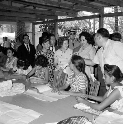 Eva Sámano con otras personas, observa los trabajos elaborados en la Unidad de Servicios Asistenciales de Acapulco