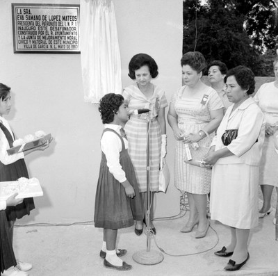 Eva Sámano de López Mateos escuchando a una niña durante la inauguracipon del desyunador de la escuela Benito Juárezm en Villa de García