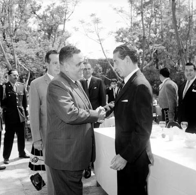 Adolfo López Mateos felicitado por un funcionario durante su cumpleaños en el jardín de Los Pinos