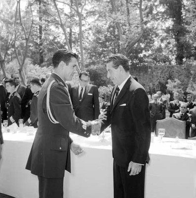 Adolfo López Mateos felicitado por un militar durante su cumpleaños en le jardín de Los Pinos