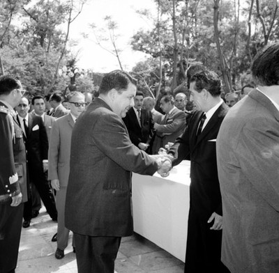 Adolfo López Mateos felicitado por un funcionario durante su cumpleaños en el jardín de Los Pinos