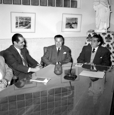 Adolfo López Mateos y empresarios conversando en una oficiana durante su visita en campaña a la fábrica de hilados y tejidos San Luis S.A., en Tulancingo