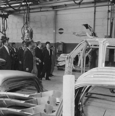Adolfo López Mateos en compañía de funcionarios públicos y empresarios, observando como se forman los automóviles Dina