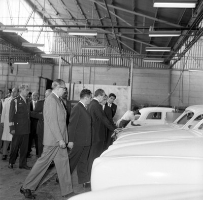 Adolfo López Mateos y comitiva supervisando la carrocería de autos, en una fábrica de Dina en Cd. Sahagún