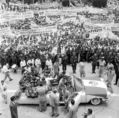 Adolfo López Mateos y Samuel León Brindis descendenciendo de un auto convertible en una plaza durante su gira de trabajo en Tuxtla Gutiérrez toma en picada