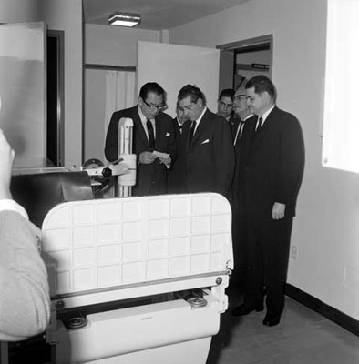 Adolfo López Mateos y José Alvares Amézquita leyendo un papel, en el momento de observar equipo médico de Terapia intensiva