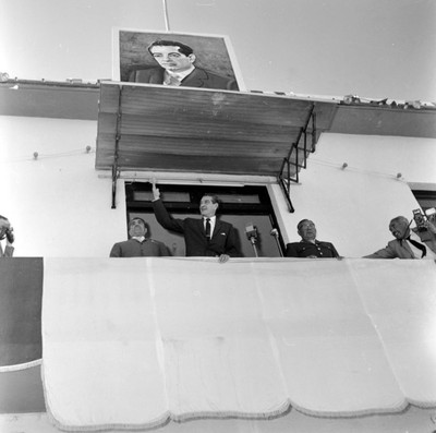 Adolfo López Mateos saludando a el pueblo de los Mochis desde el balcón de un edificio, durante una gira de trabajo
