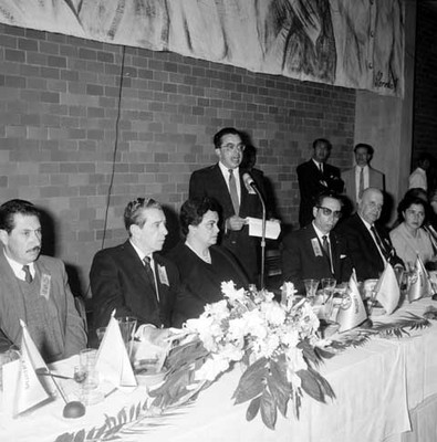 Adolfo López Mateos escuchando un discurso pronunciado por un funcionario, durante un banquete en el Centro Deportivo Moctezúma