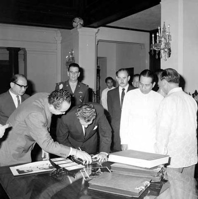 Adolfo López Mateos acompañado de funcionarios firma fotografía en la biblioteca de Filipinas