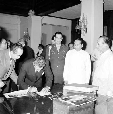 Adolfo López Mateos firma unos documentos en la biblioteca donde se inaugura la exposición El Libro Mexicano