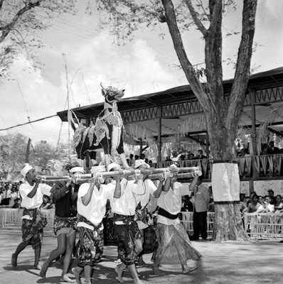 Hombres cargando en andas un dragón, durante una ceremonia en honor a López Mateos a su llegada a Balí