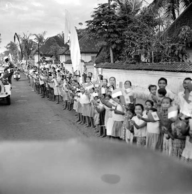 Habitantes de Bali ondeando banderas al paso del desfile con motivo de la visita de Adolfo López Mateos