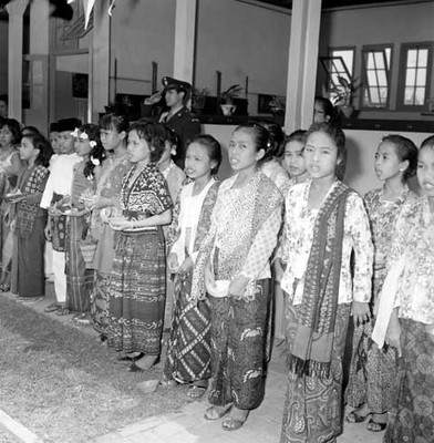 Grupo coral con trajes extranjeros cantando durante la visita de Adolfo López Mateos a la escuela República de México en Indonesia