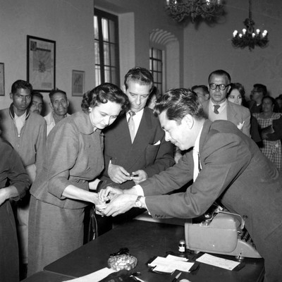 Adolfo López Mateos observa a un empleado colocarle tinta en el pulgar a Eva Sámano de López Mateos